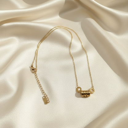Gold necklace on a light gray background