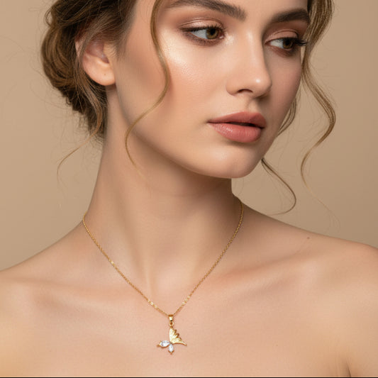 Woman wearing a golden necklace with a butterfly pendant against a beige background