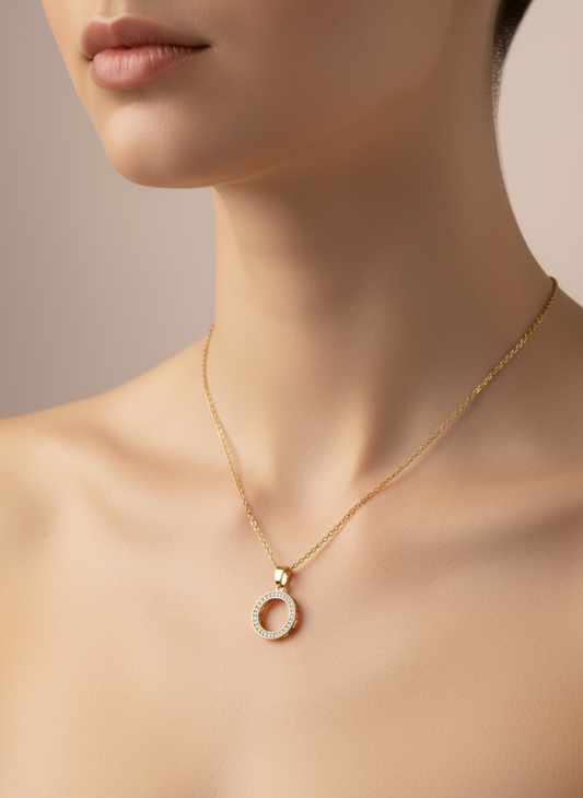Golden necklace with a pendant on a model against a neutral background