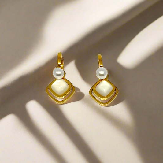 Gold earrings with pearls on a white background