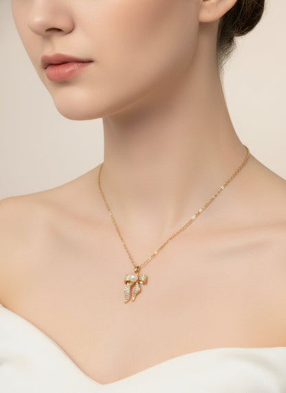 Gold bow-shaped necklace with a pearl center on a model