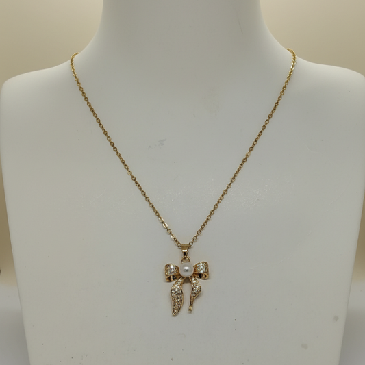 Gold necklace with a bow pendant on a mannequin bust.
