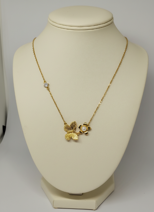 Gold necklace with a floral pendant on a mannequin bust against a plain background
