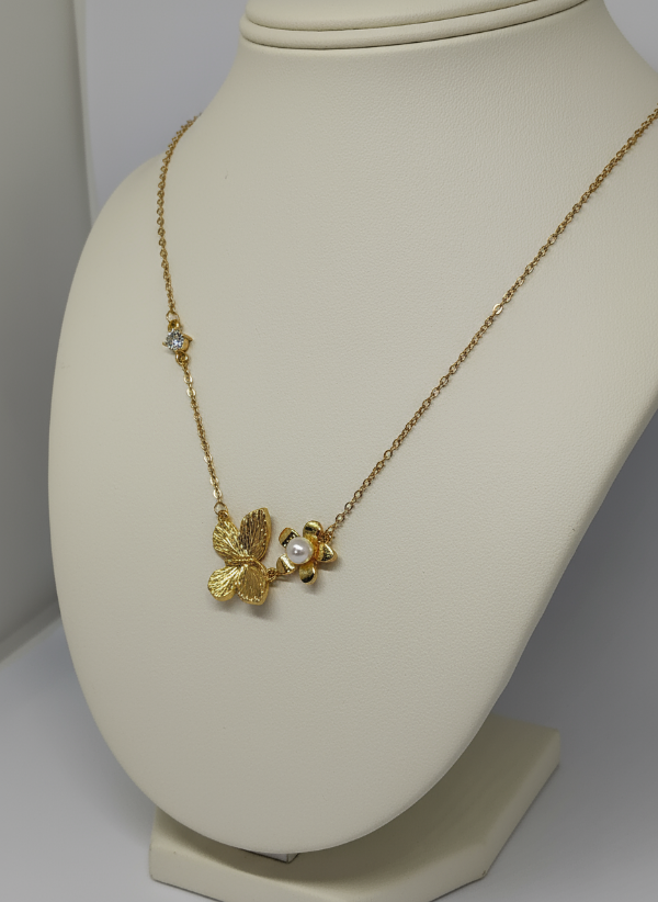 Golden necklace with a butterfly pendant on a mannequin bust.