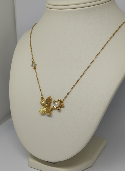 Golden necklace with a butterfly pendant on a mannequin bust.