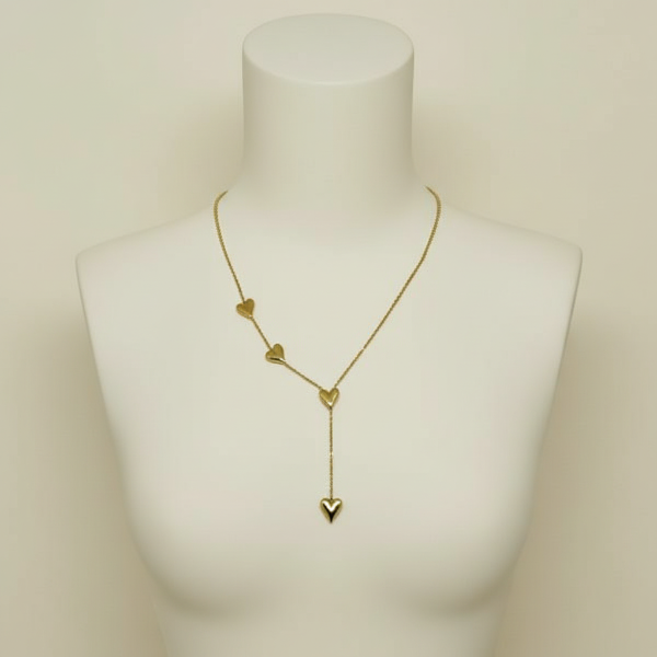 Golden heart-shaped necklace on a mannequin bust against a beige background