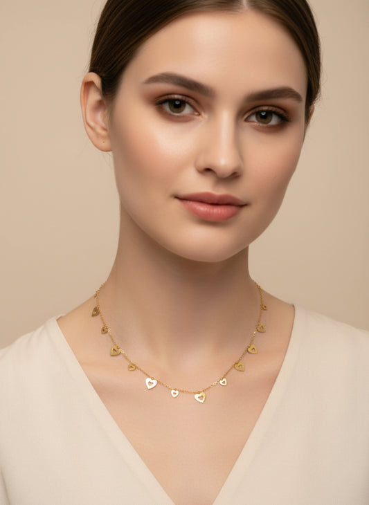Woman wearing a golden necklace with heart-shaped pendants on a beige background