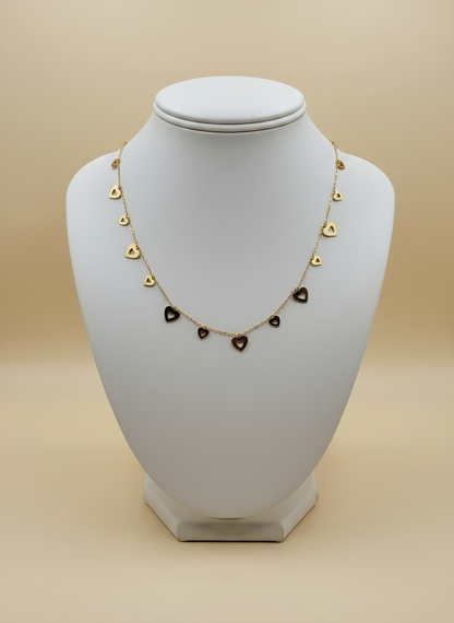 Necklace with heart-shaped pendants on a white mannequin bust against a beige background