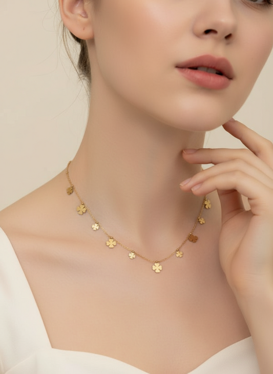 Gold necklace with small pendants on a model against a neutral background