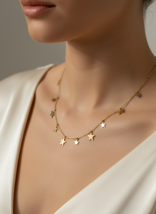Gold star necklace worn by a model against a neutral background
