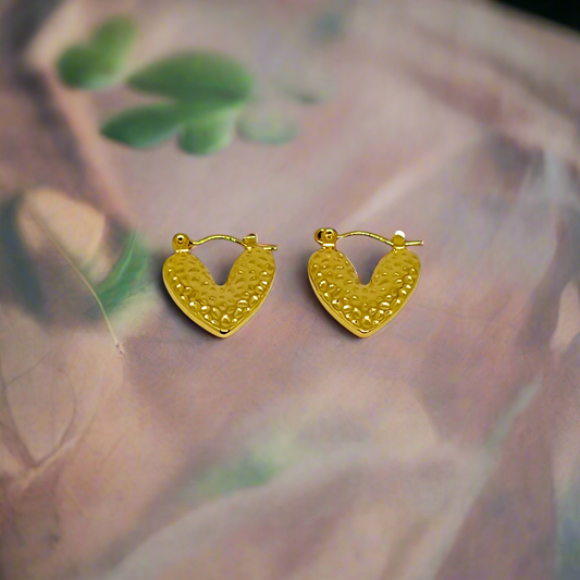 Gold heart-shaped earrings on a white background