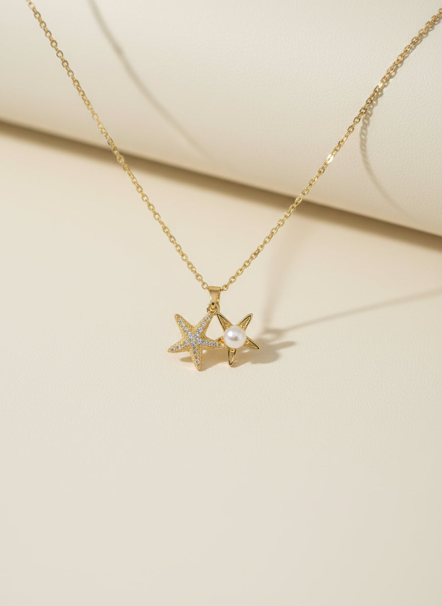 Golden necklace with star-shaped pendant on a beige background