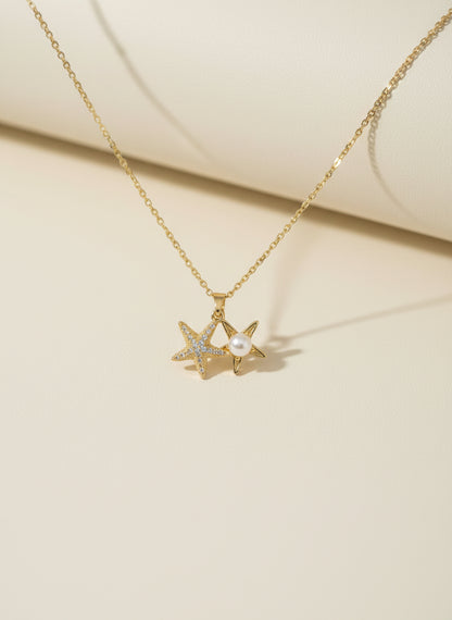 Golden necklace with star-shaped pendant on a beige background