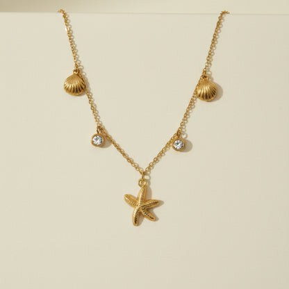 Golden necklace with a starfish pendant on a gray card